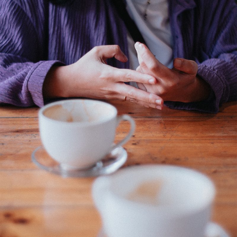 image d'une femme qui discute avec sur la table des tasses à café lors d'un café rencontre